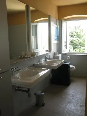 a bathroom with two sinks and two windows at Casa Le Bouganville in Sant Vicenç de Montalt