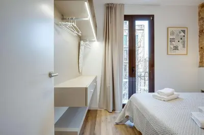 a white bedroom with a bed and a window at LucasLand Apartments Barcelona in Barcelona