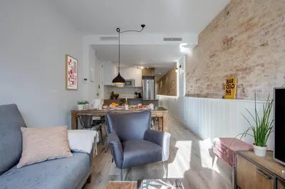a living room with a couch and a table and a kitchen at LucasLand Apartments Barcelona in Barcelona