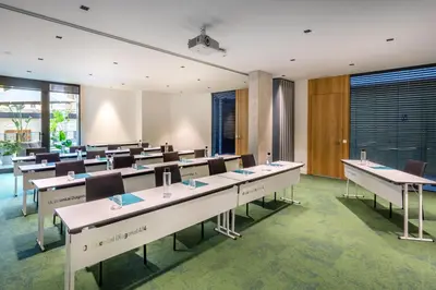 a conference room with tables and chairs and windows at Occidental Diagonal 414 in Barcelona
