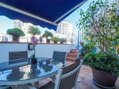 a patio with a table and chairs and potted plants at Benito Apartment by Hello Homes Sitges in Sitges