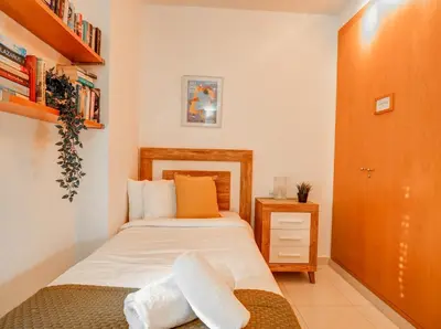 a small bedroom with a bed and a wooden cabinet at Benito Apartment by Hello Homes Sitges in Sitges