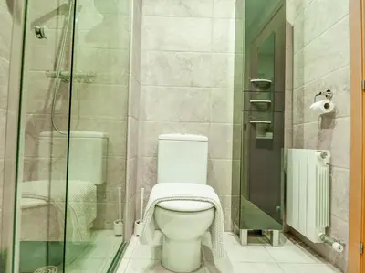 a bathroom with a toilet and a glass shower at Benito Apartment by Hello Homes Sitges in Sitges
