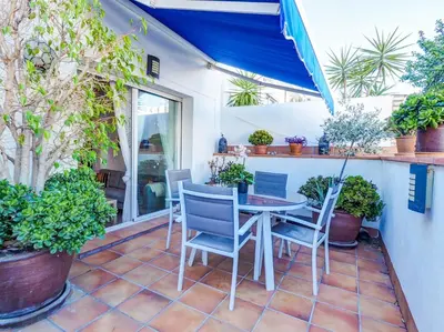 a patio with a table and chairs and plants at Benito Apartment by Hello Homes Sitges in Sitges