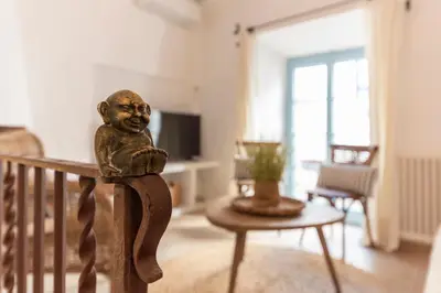 a statue of a child sitting on a railing in a living room at Casa Azul by Hello Homes Sitges in Sitges
