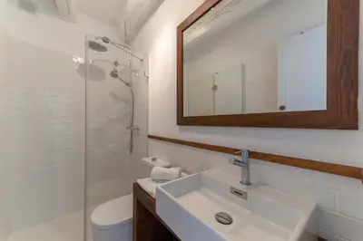 a bathroom with a sink and a mirror and a toilet at Casa Azul by Hello Homes Sitges in Sitges