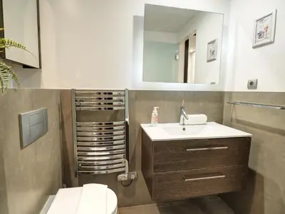 a bathroom with a sink and a toilet and a mirror at Chic by Hello Homes Sitges in Sitges