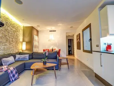 a living room with a blue couch and a table at Chic by Hello Homes Sitges in Sitges