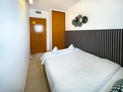 a bedroom with a large white bed with a fan at Sunlight by Hello Homes Sitges in Sitges