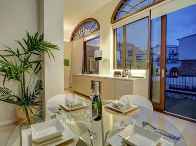 a glass table and chairs in a room with a window at En Vogue by Hello Homes Sitges in Sitges