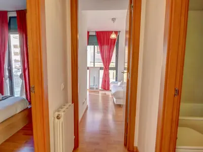 a hallway with a room with a bed and a window at Mimosa Apartment by Hello Homes Sitges in Sitges