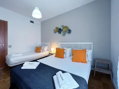 a bedroom with two beds with orange pillows at Stay U-nique Apartments Diagonal in Barcelona