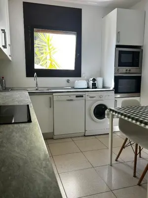 a kitchen with a washing machine and a window at ALOJAMIENTO CON JARDIN 20KM BARCELONA in Vilassar de Dalt