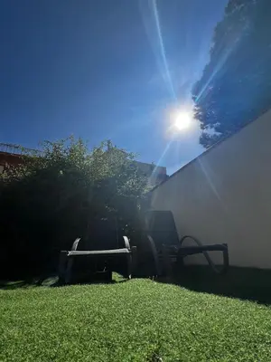 two chairs in a yard with the sun in the background at ALOJAMIENTO CON JARDIN 20KM BARCELONA in Vilassar de Dalt