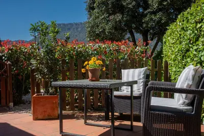a table and chairs on a patio with flowers at Caseta de Fusta in Aiguafreda