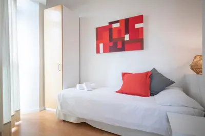 a bedroom with a white bed with a red pillow at You Stylish Sagrada Familia Apartments in Barcelona