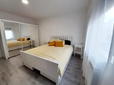 a bedroom with a bed and a large mirror at Nur Apartment in Terrassa