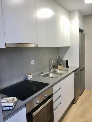 a kitchen with white cabinets and a sink at Vilamarlux IV in Vilassar de Mar