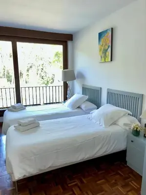two beds in a bedroom with a large window at Casa Vila Reyes in Sant Vicenç de Montalt