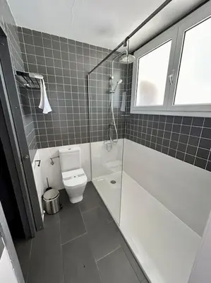 a bathroom with a shower and a toilet and a window at Casa Vila Reyes in Sant Vicenç de Montalt