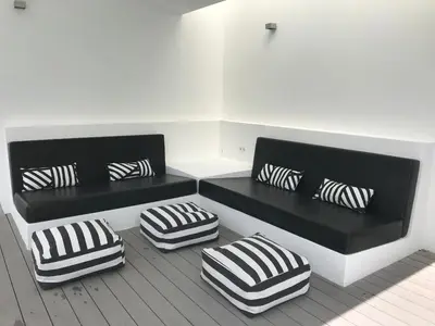 two black and white benches with pillows on the floor at Casa Vila Reyes in Sant Vicenç de Montalt