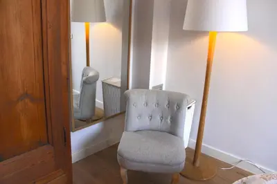 a room with a chair and a lamp and a mirror at Mr. Serrano Apartments in Barcelona