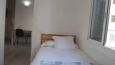 a bedroom with a bed with white sheets and a window at Chopin Magic Fountain in Barcelona