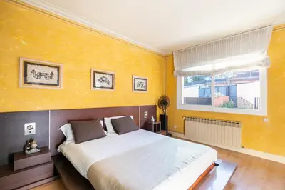 a bedroom with a large bed and a window at TOWANDA HOUSE in Sant Just Desvern