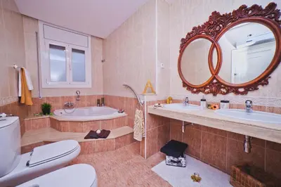 a bathroom with two sinks a toilet and a mirror at Villa Victoria Barcelona in Barcelona