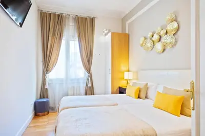 a white bedroom with two beds and a window at Villa Victoria Barcelona in Barcelona