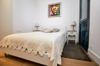 a white bedroom with a bed and a window at Lux Apartments Barcelona in Barcelona