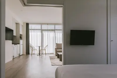 a bedroom with a bed and a kitchen with a table at CIM Aparthotel in Sant Cugat del Vallès