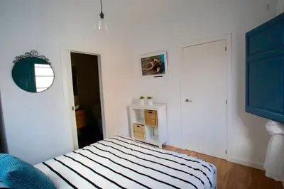 a white room with a bed and a mirror at LOVELY FLAT FIRA MWC in Hospitalet de Llobregat
