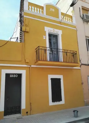 a yellow building with a balcony and a door at LOVELY FLAT FIRA MWC in Hospitalet de Llobregat