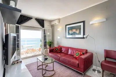 a red couch in a living room with a view of the ocean at Apartment in front of the Beach in Pineda de Mar