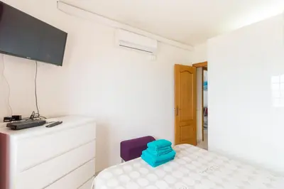 a small bedroom with a bed and a tv at Apartment in front of the Beach in Pineda de Mar