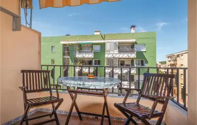 a table and chairs on a balcony with a building at Gorgeous Apartment In Pineda De Mar in Pineda de Mar