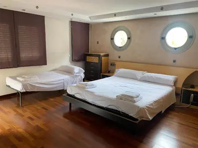 two beds in a room with two windows at Can Ramón in Caldes de Montbui