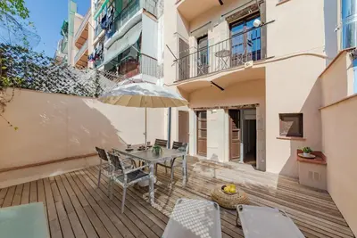 a patio with a table and chairs and an umbrella at Sant Pau Ramblas Apartments Serennia in Barcelona