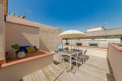 a balcony with a table and chairs and an umbrella at Sant Pau Ramblas Apartments Serennia in Barcelona