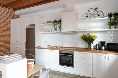 a white kitchen with white cabinets and a sink at Casa Cosi - Putxet 4 in Barcelona