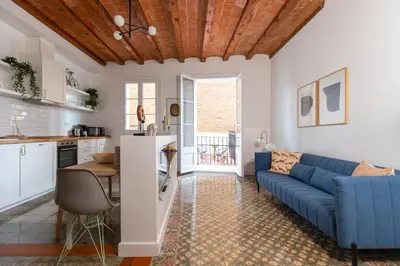 a living room with a blue couch and a table at Casa Cosi - Putxet 4 in Barcelona