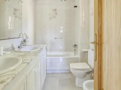 a white bathroom with two sinks and a toilet at Villa in Arenys de Mar with Sea View in Arenys de Mar