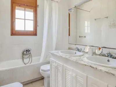 a bathroom with two sinks and a tub and a toilet at Villa in Arenys de Mar with Sea View in Arenys de Mar