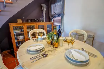 a wooden table with plates and wine glasses on it at Montroig Zen Penthouse by Hello Homes Sitges in Sitges