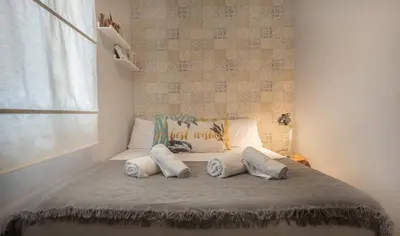 a bed with three pillows on it in a bedroom at Stay Unique Apartments Aprestadora in Hospitalet de Llobregat