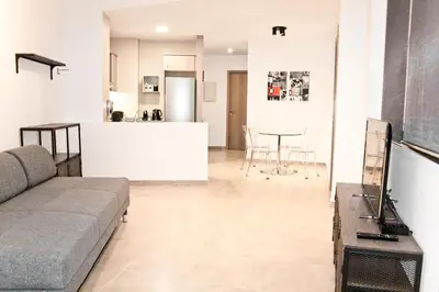 a living room with a couch and a kitchen at Urban Manesa city center apartment with private patio in Manresa