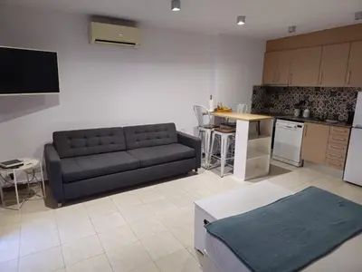 a living room with a couch and a kitchen at Mataró Center Apartment in Mataró