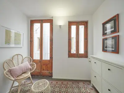 a white room with a table and chairs and a door at BarcelonaForRent Alessandra Ramblas in Barcelona