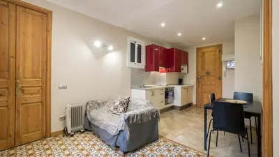a kitchen with red cabinets and a table in a room at Acogedor apartamento de 2 dormitorios in Barcelona
